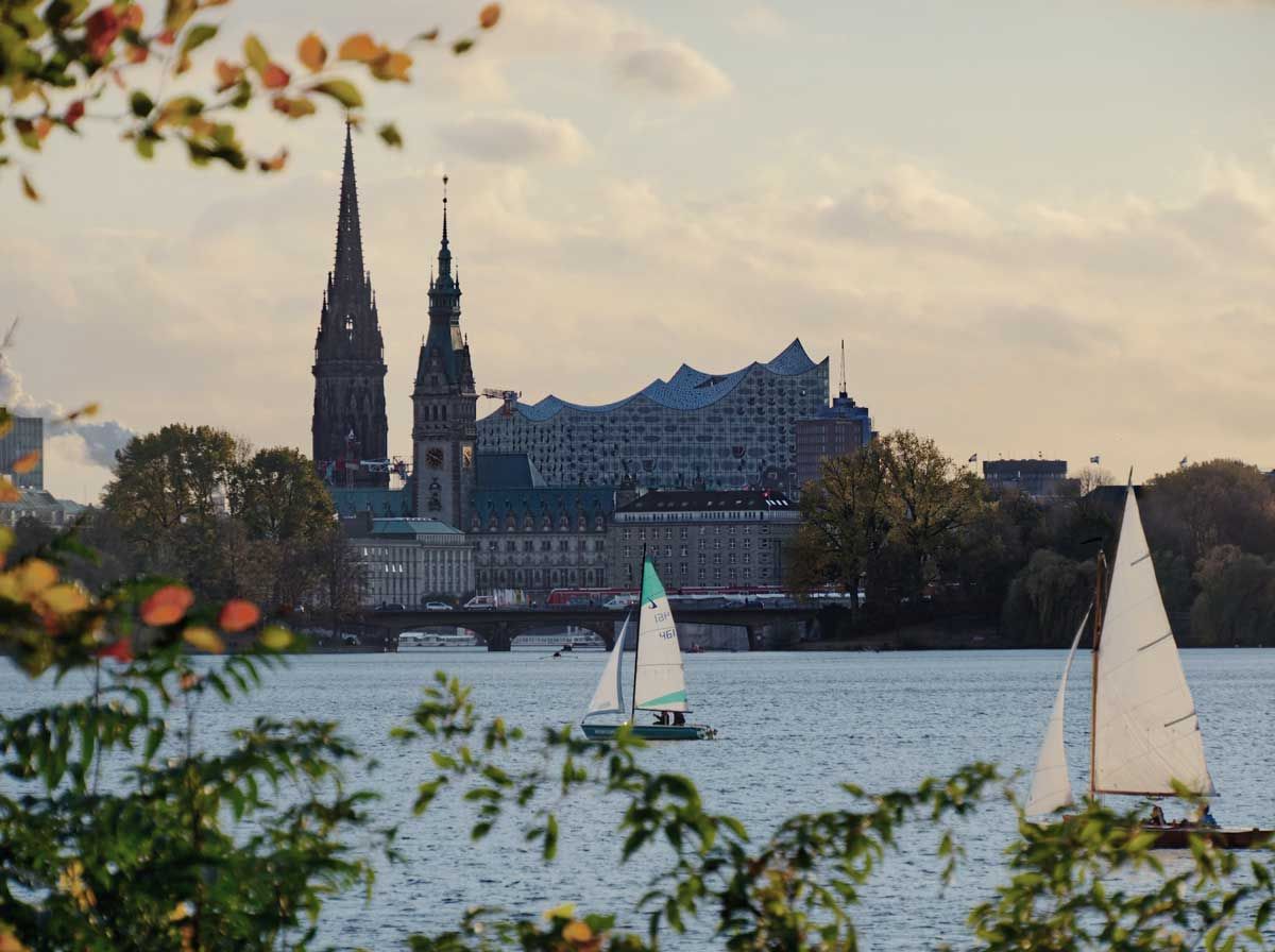 Alster mit Elbphilharmonie im Hintergrund und Segelschiffen